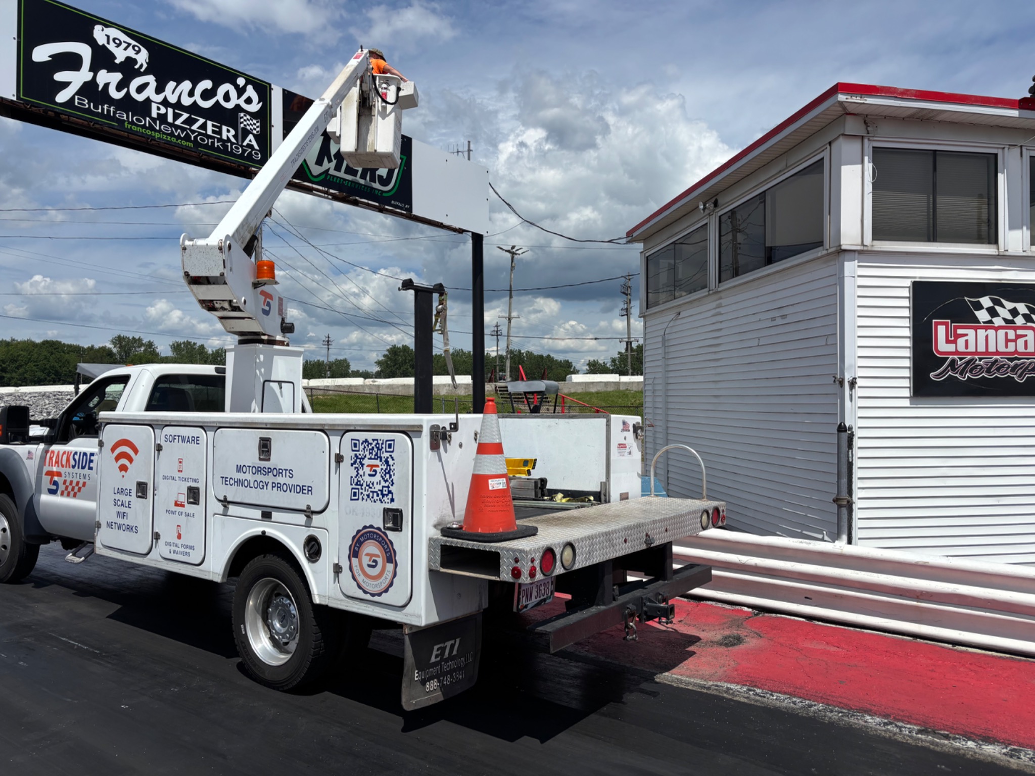 Trackside bucket truck and crew beside the tower at Lancaster Motorplex.