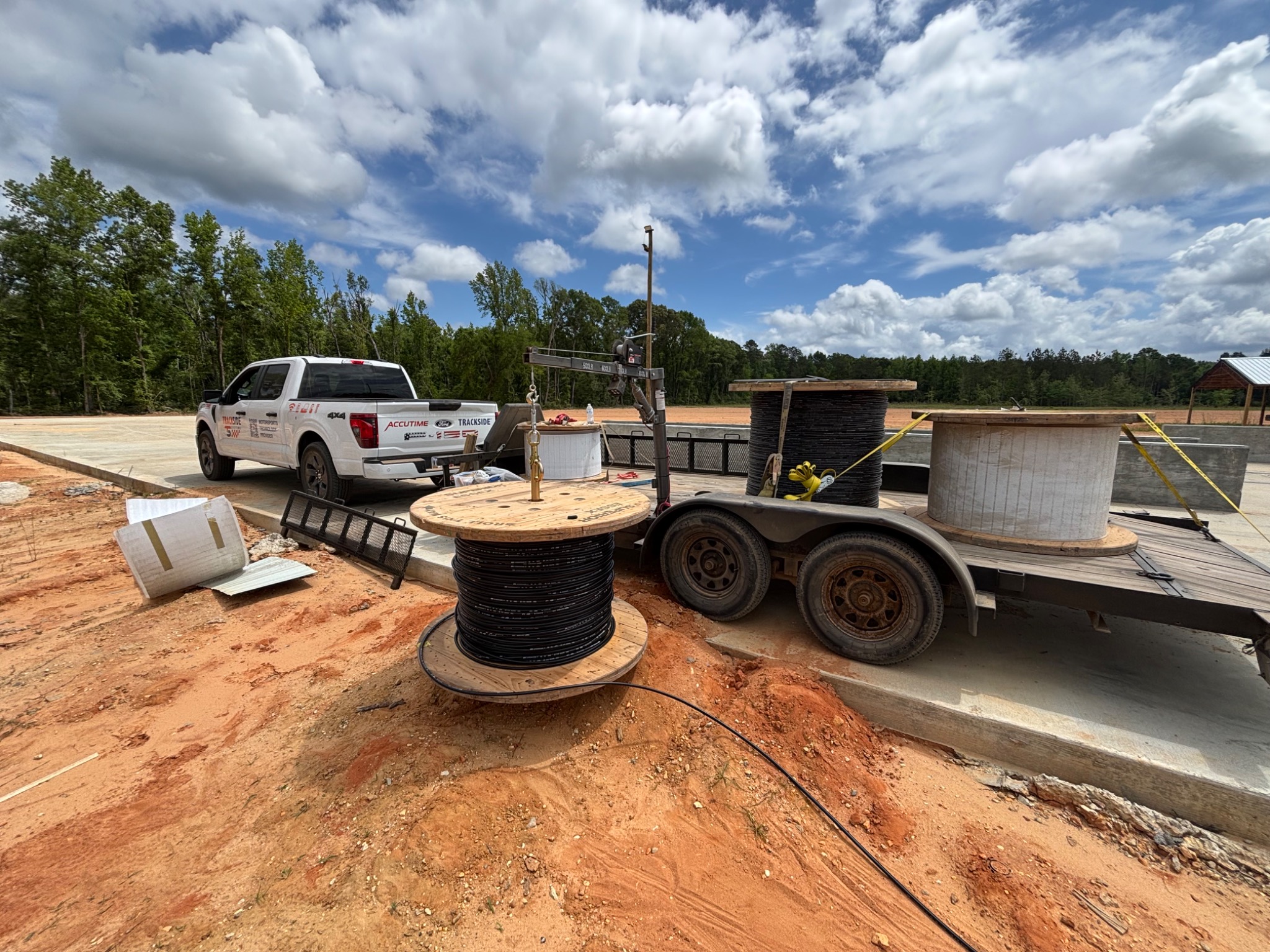 Trackside spool trailer and large cable reels on site.